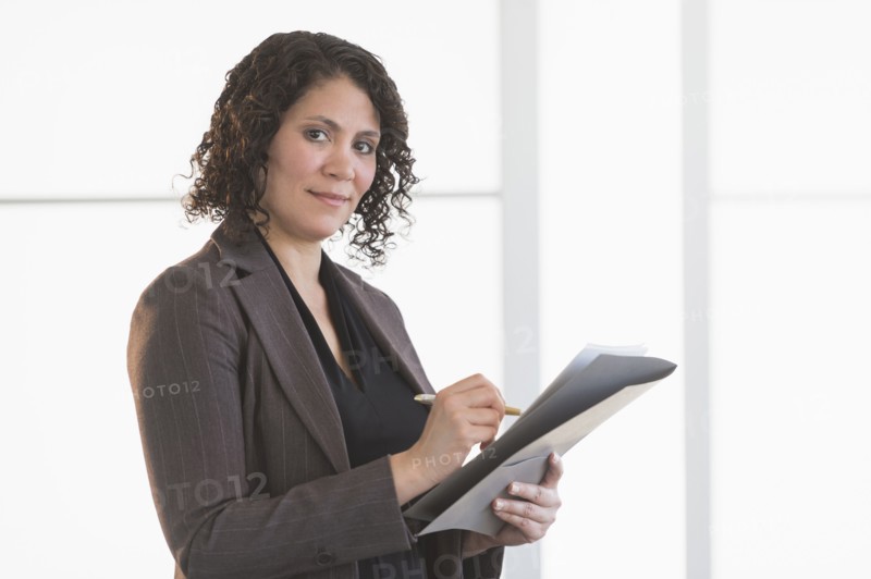 Hispanic businesswoman writing in office