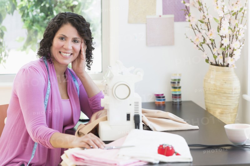 Hispanic dressmaker working at sewing machine