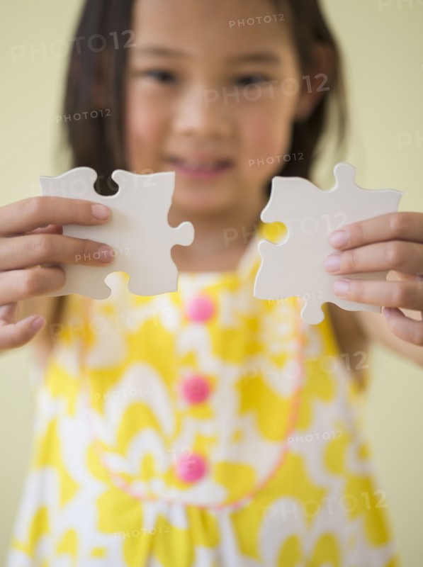 Korean girl connecting jigsaw pieces