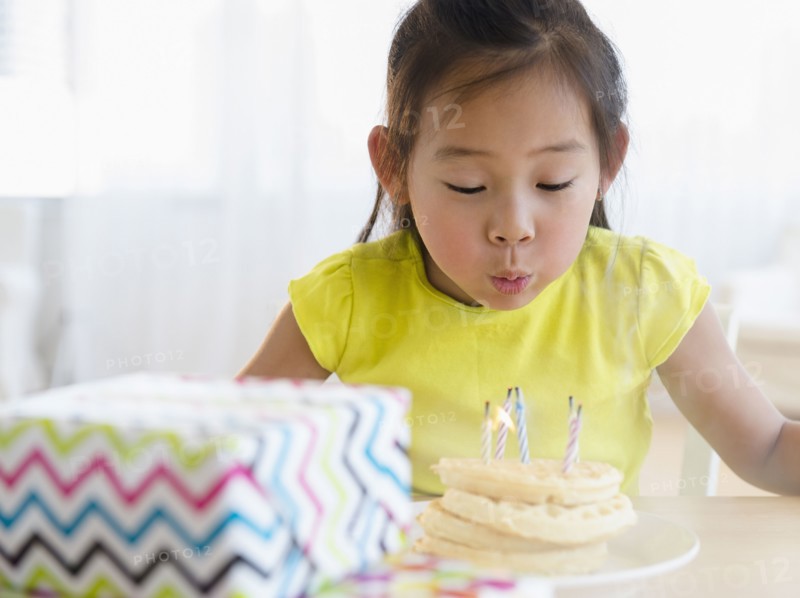 Korean girl blowing out candles on birthday cake