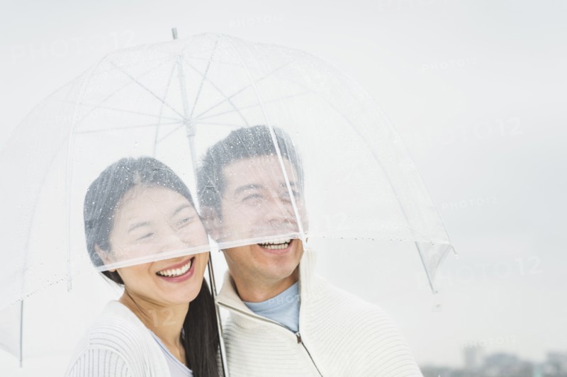 Couple laughing under umbrella