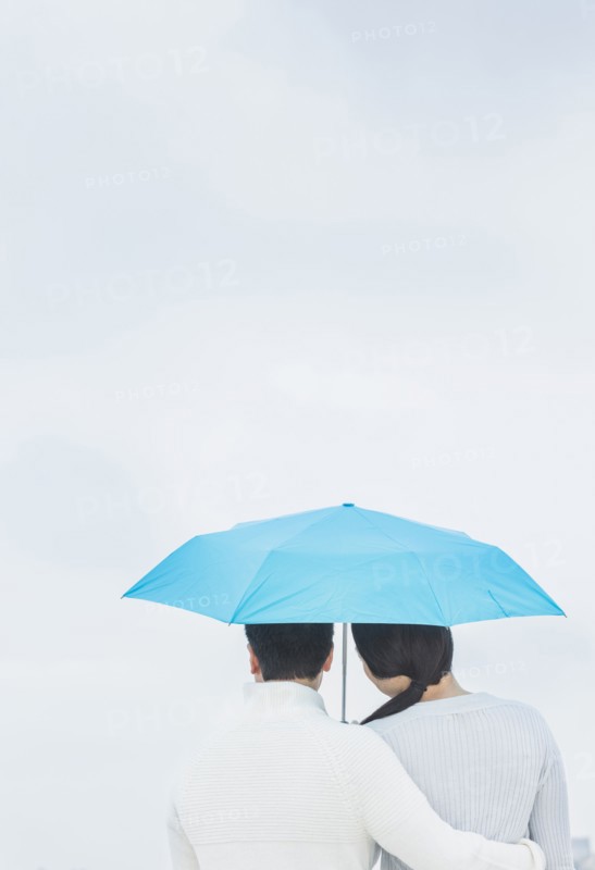 Couple hugging under umbrella