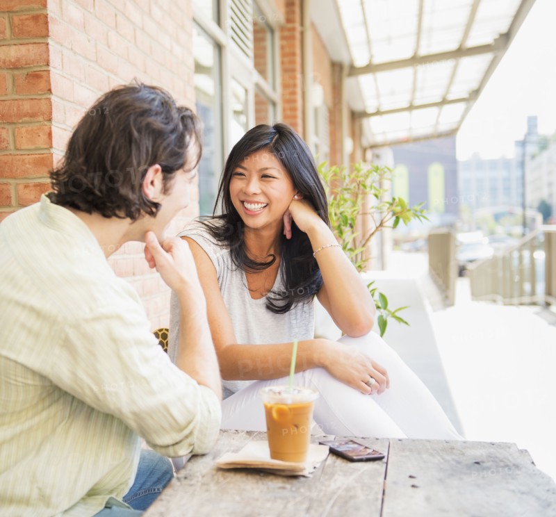 Couple enjoying iced coffee at sidewalk cafe