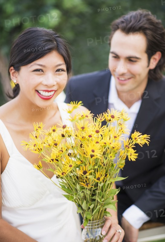 Newlywed couple holding bouquet