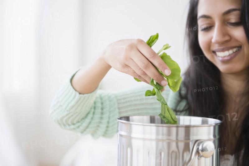 Asian woman composting lettuce