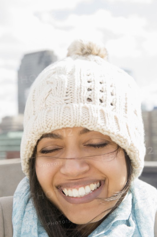 Close up of Asian woman smiling in knit hat with eyes closed