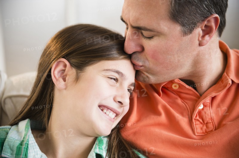 Caucasian father kissing daughter's forehead