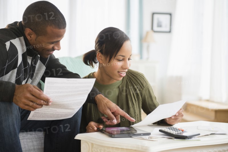 Couple paying bills in living room