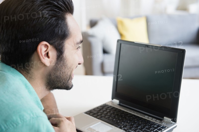 Mixed race man using laptop