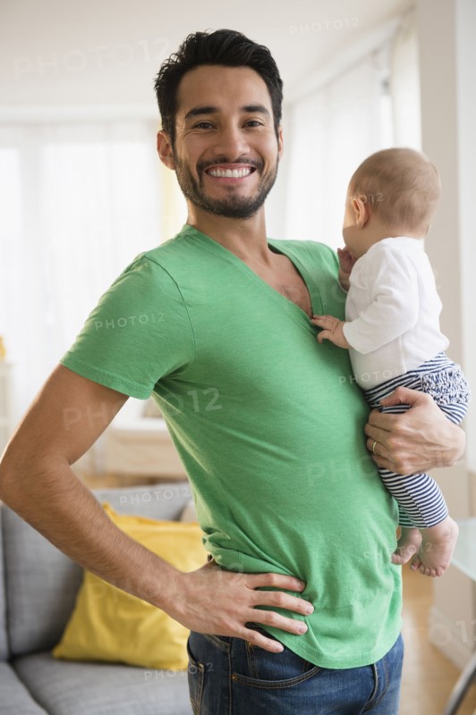 Father holding baby in living room