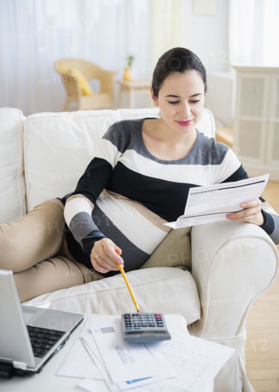 Pregnant Caucasian woman paying bills