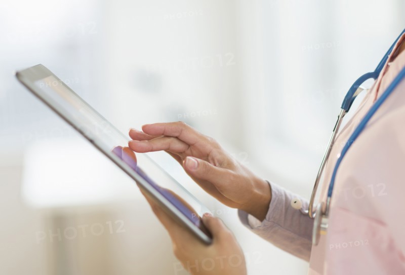 Hispanic nurse using digital tablet in hospital