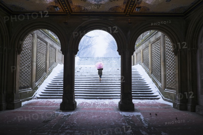 Asian woman walking up steps into snow