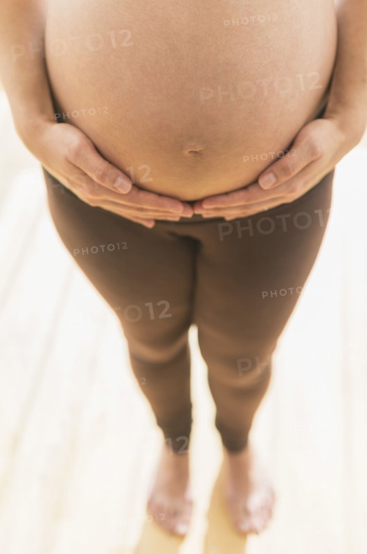 Pregnant Hispanic woman holding her belly