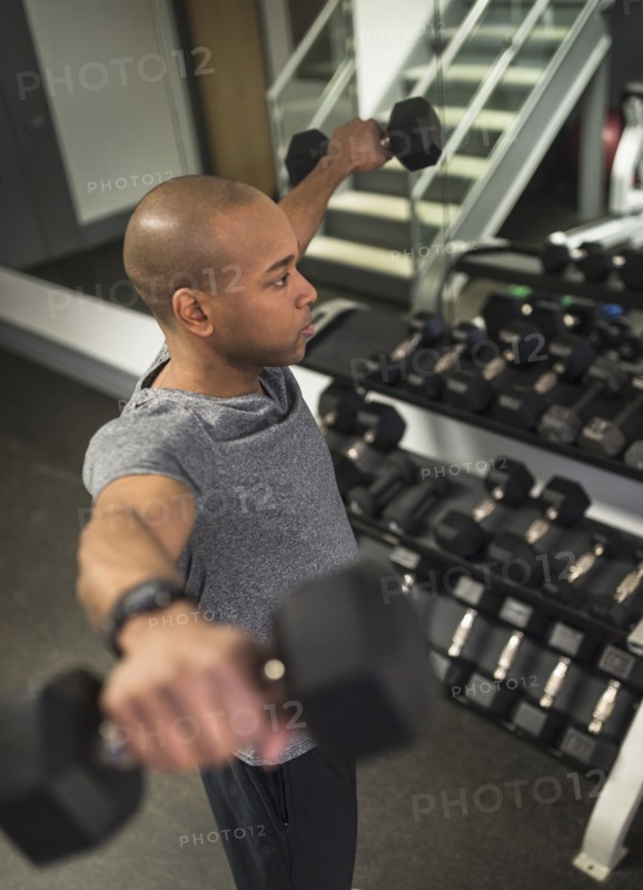 Black man lifting weights in gym