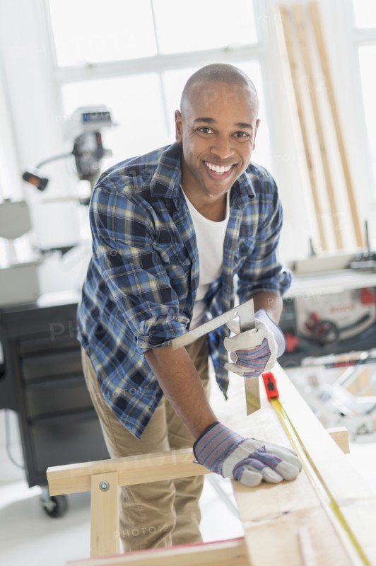 Black carpenter working in shop