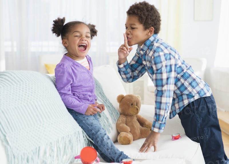 Black children playing on sofa