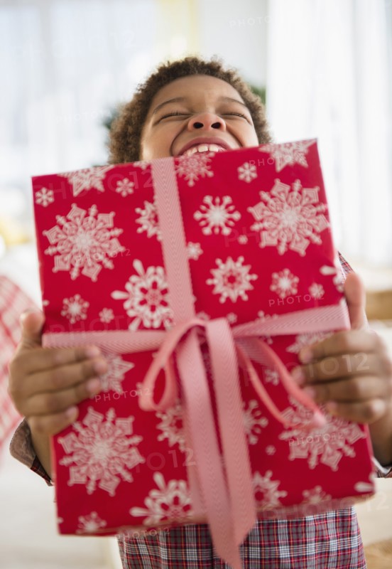 Black boy holding Christmas present