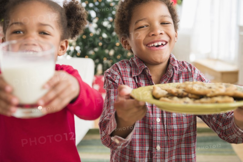 Black children with milk and cookies for Santa Claus