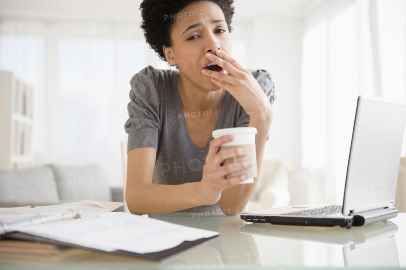 Black woman yawning at desk