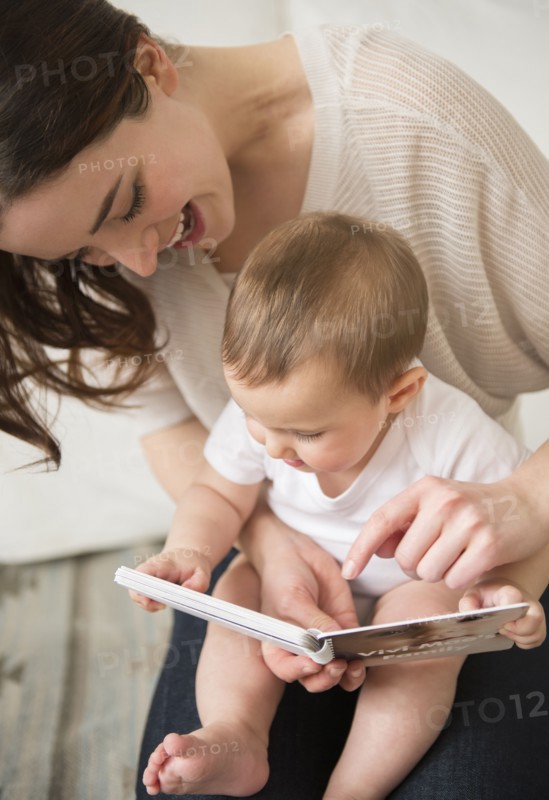 Mother and baby reading in living room