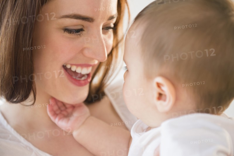 Smiling mother playing with baby