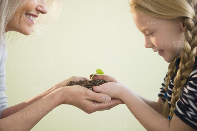 Senior Caucasian woman and granddaughter admiring plant shoot
