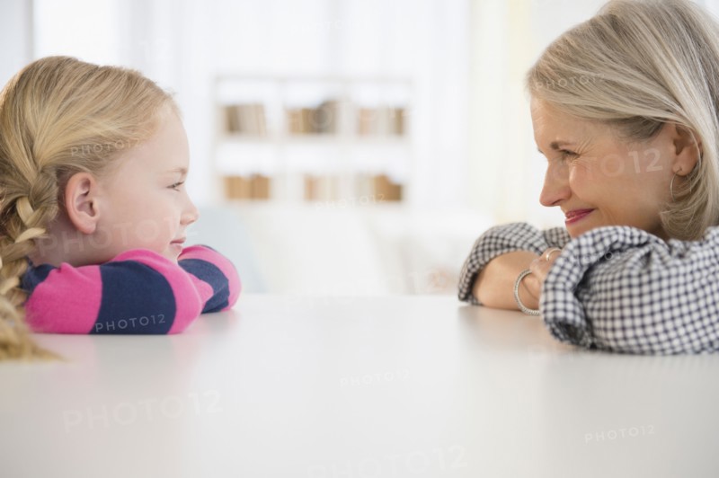 Senior Caucasian woman and granddaughter sitting at table