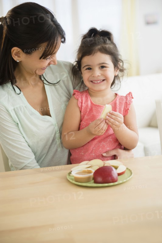 Hispanic mother and daughter eating together