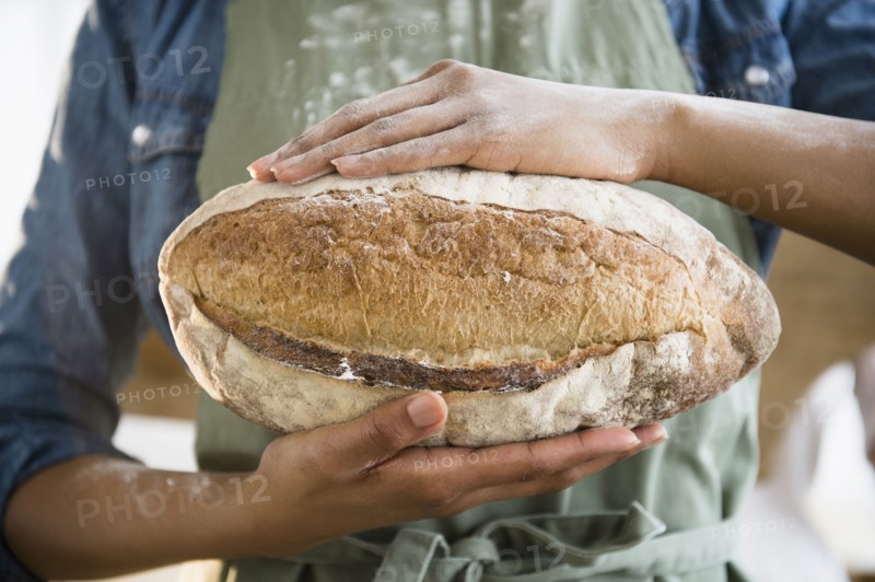Mixed race woman holding loaf of bread