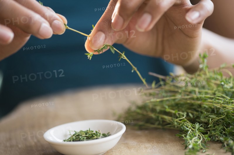 Mixed race woman trimming herbs