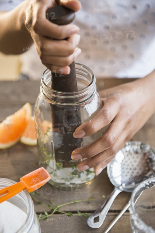Mixed race woman muddling cocktail