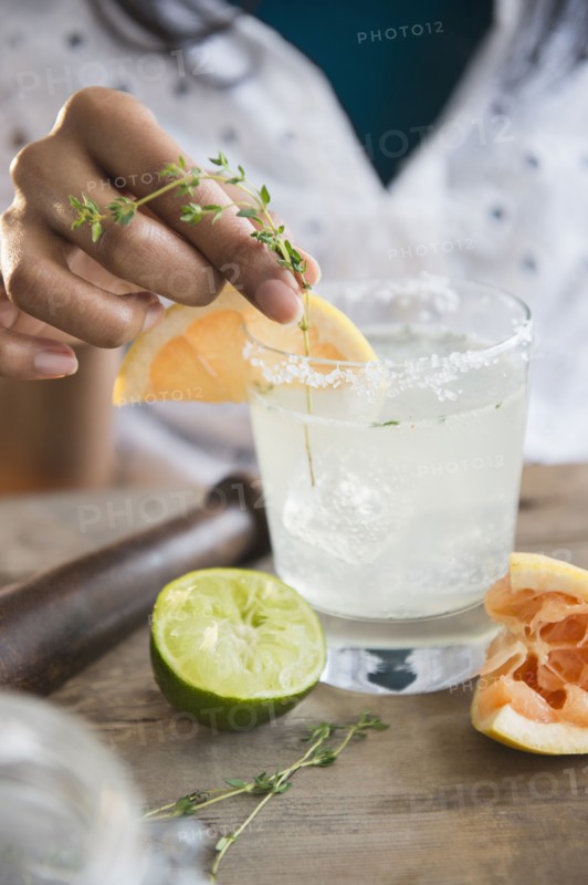 Mixed race woman making cocktail