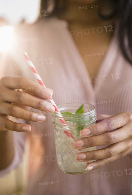 Mixed race woman drinking cocktail