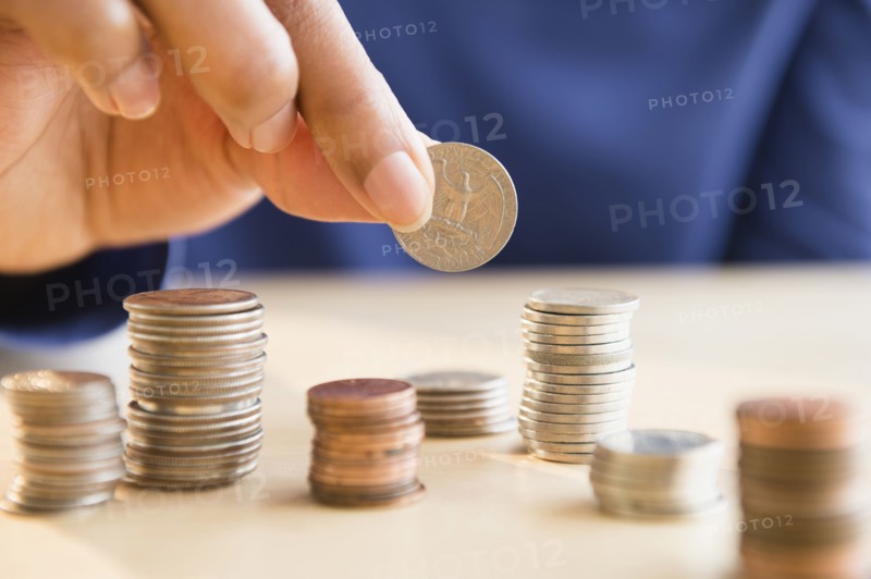 Mixed race woman stacking coins