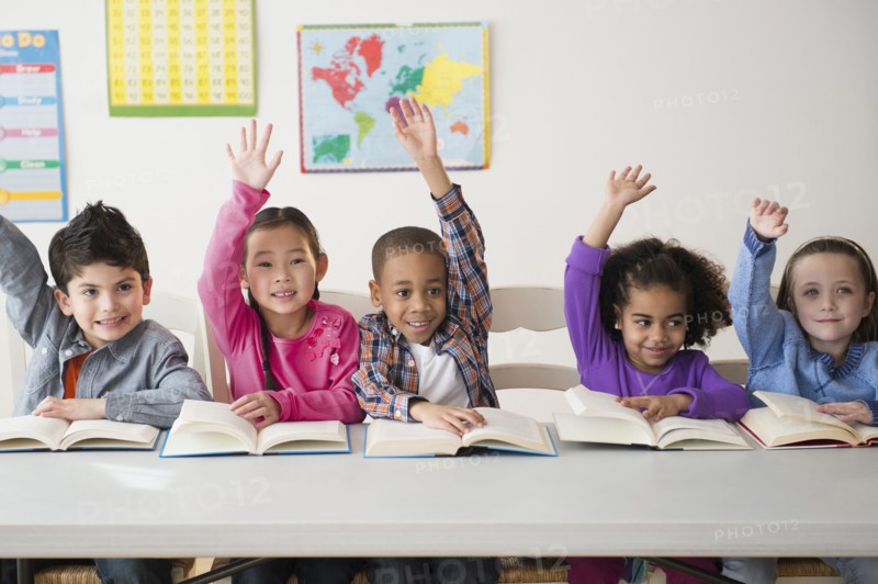 Students raising hands in classroom