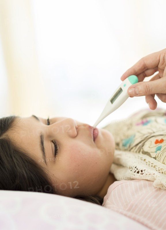 Hispanic girl taking her temperature