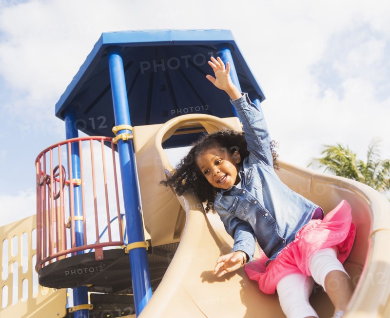 Mixed race girl playing on playground