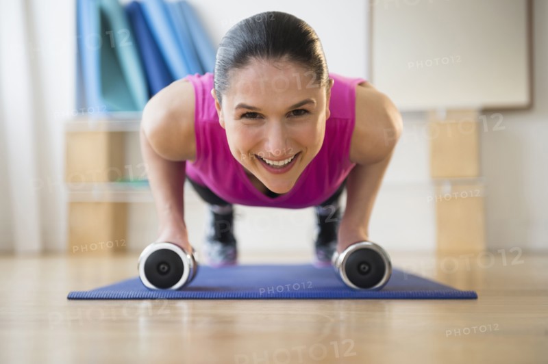 Caucasian woman doing push ups on yoga mat