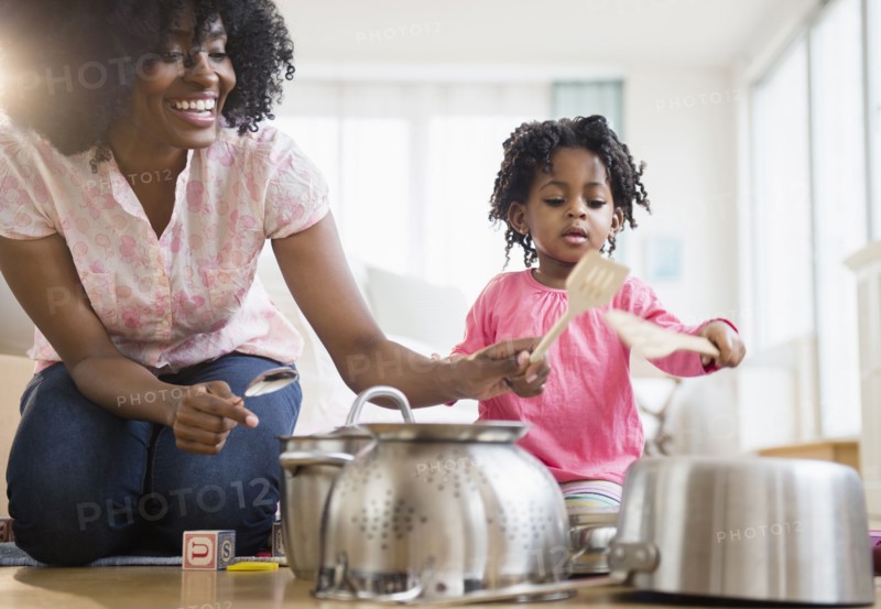 Mother and daughter playing with pots and pans