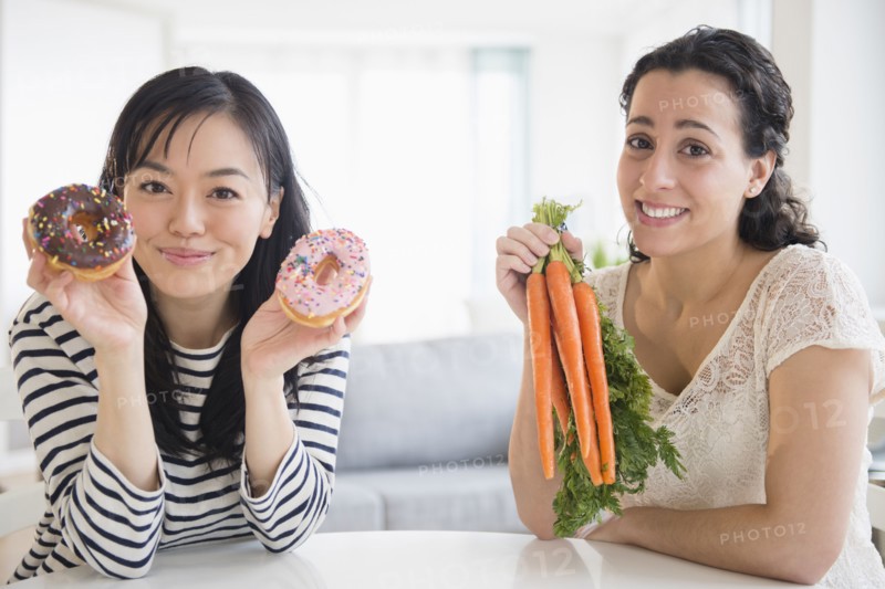 Women choosing between donuts and carrots