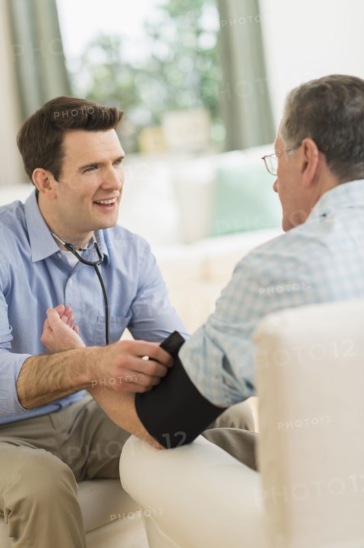 Caucasian doctor taking patient's blood pressure at home
