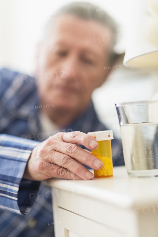 Senior Caucasian man taking medication