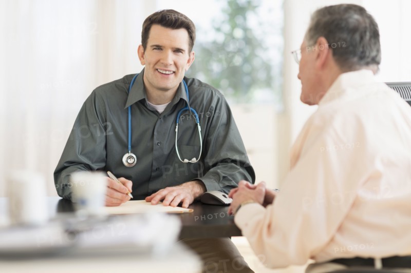Caucasian doctor and patient talking in office