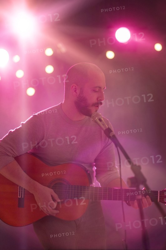 Hispanic musician playing guitar on stage