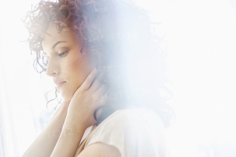 Hispanic woman holding chin in hands