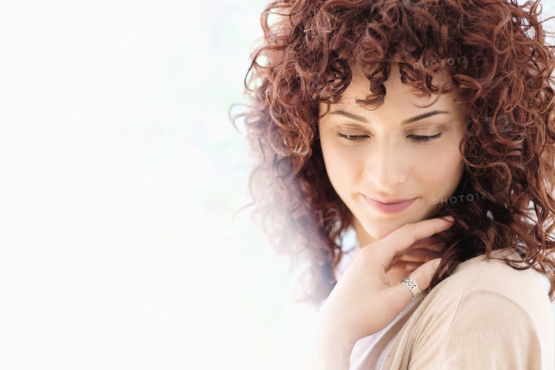 Hispanic woman holding chin in hands