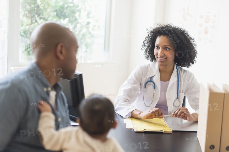 Father with baby talking to doctor