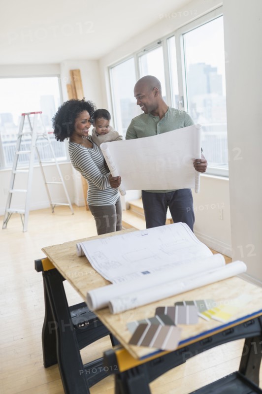 Family examining blueprints in new home