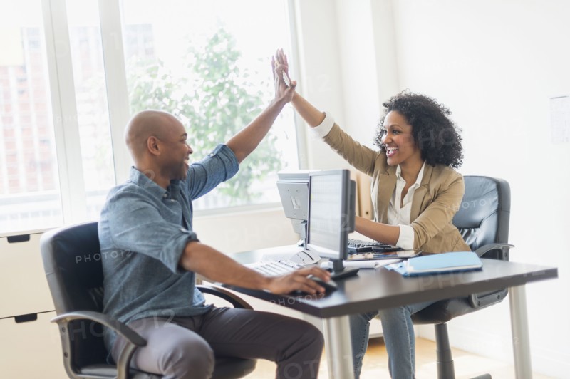 Business people high fiving in office
